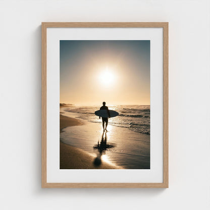 lone-longboarder-walking-across-sunlit-beach-cin 18x24-natural frame frame