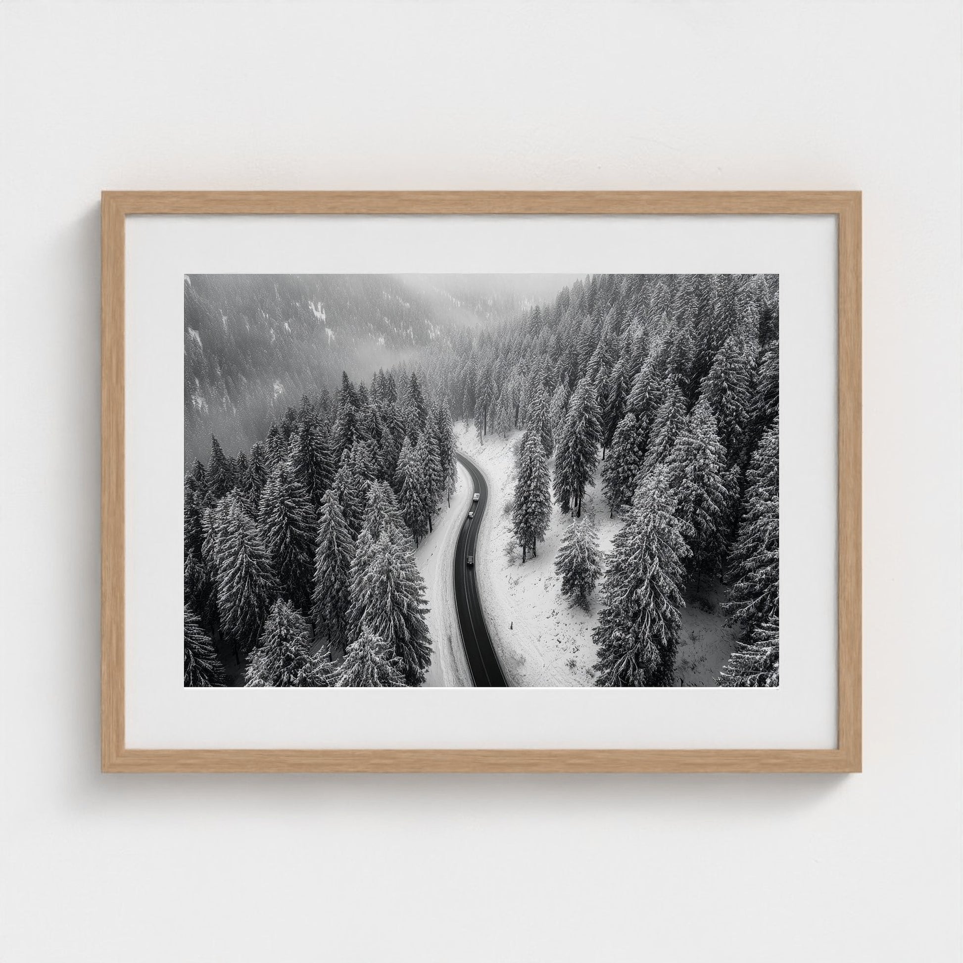 aerial-of-snow-covered-road-slicing-through-dark 24x18-natural frame frame
