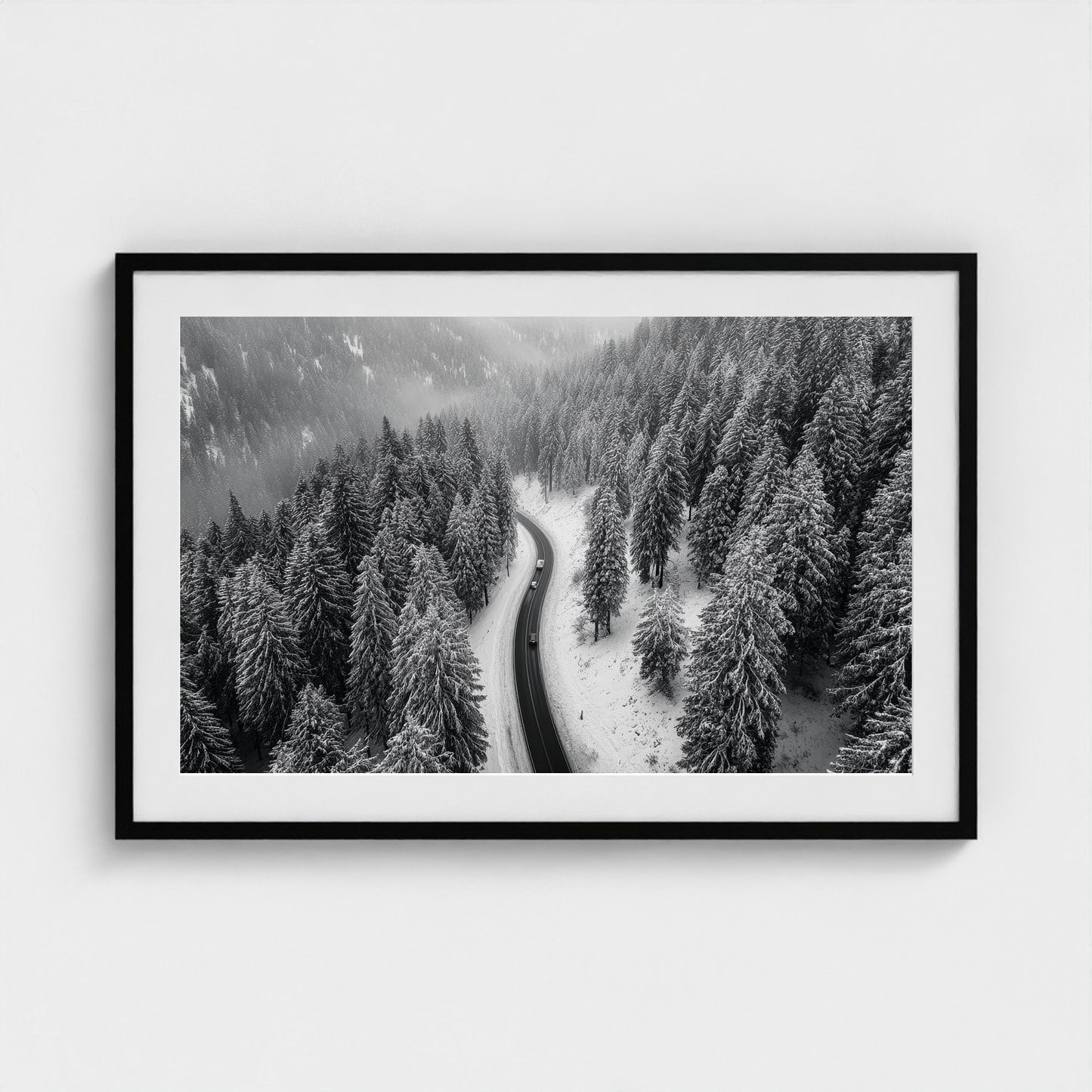 aerial-of-snow-covered-road-slicing-through-dark 36x24-black frame frame