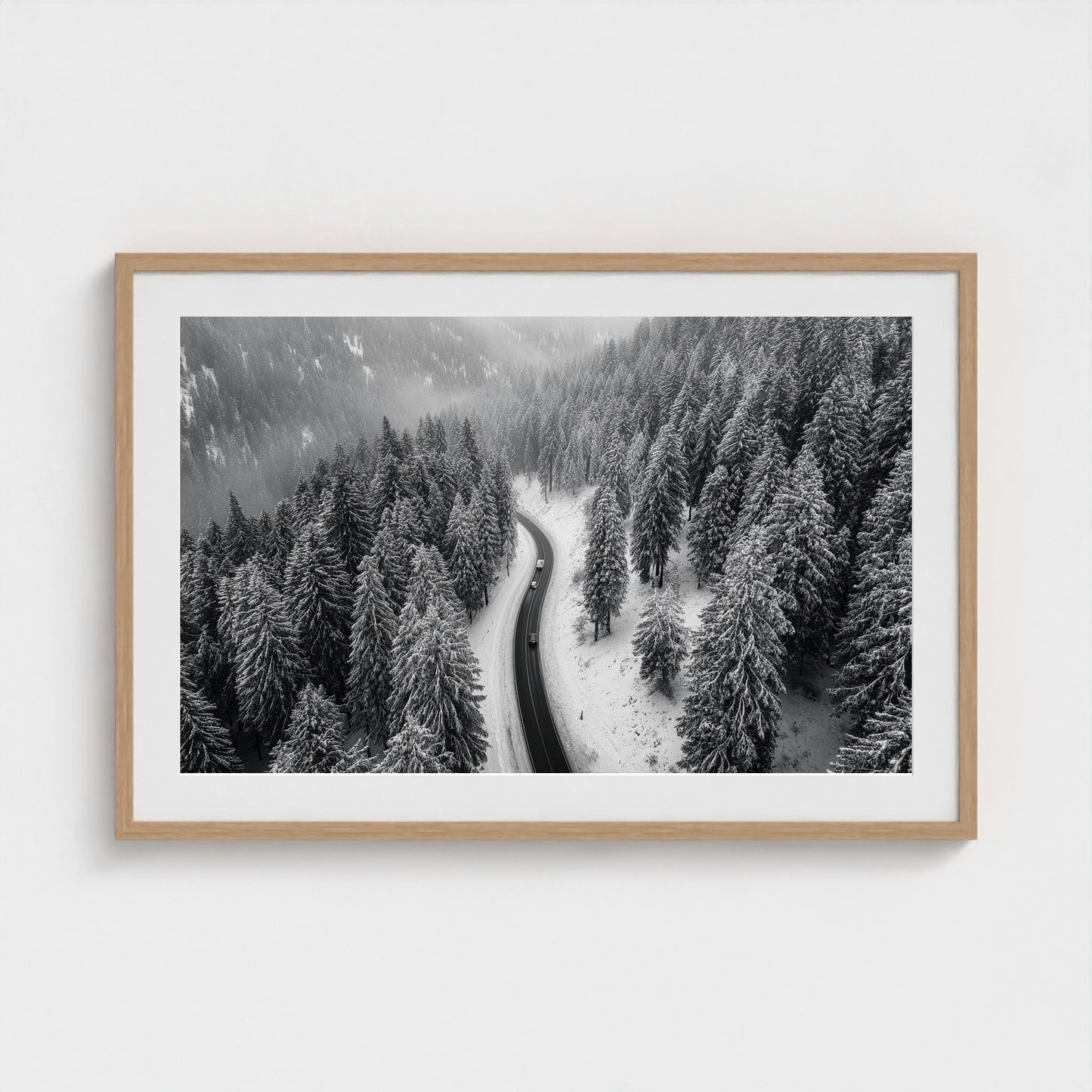 aerial-of-snow-covered-road-slicing-through-dark 36x24-natural frame frame